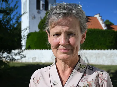 Præst Eigil Bank okesen foran en stor kirke